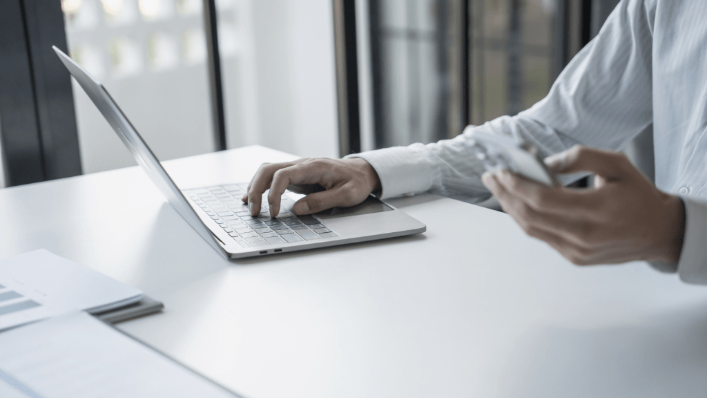 Man at laptop with phone
