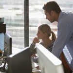 Business people working at laptop and computer in sunny office