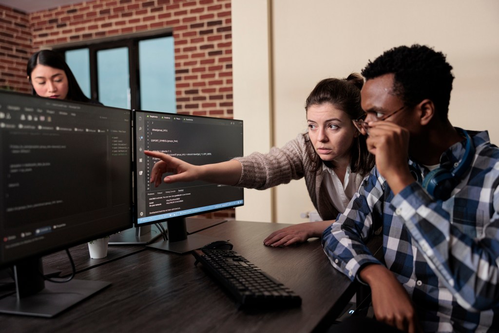 software developer signaling on screen data breach and deactivated security system.